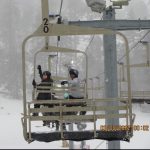 students waving from ski chair lift