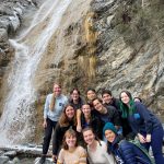 group of students in front of waterfall